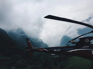 Helicopter hovering over the Andes mountains with a dramatic sunset backdrop.