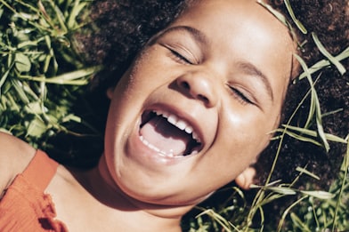 smiling girl lying on green grass