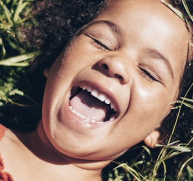 smiling girl lying on green grass