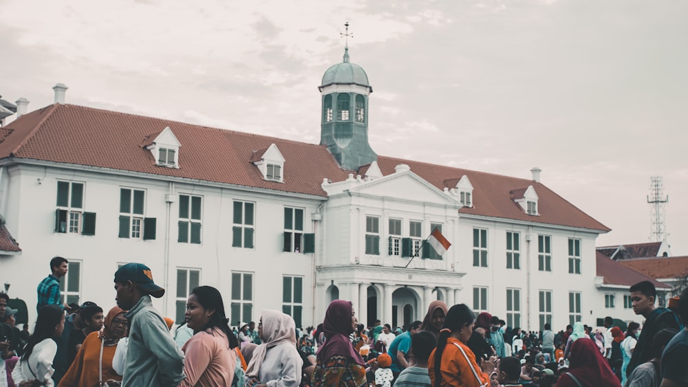 people in front of white concrete building during daytime