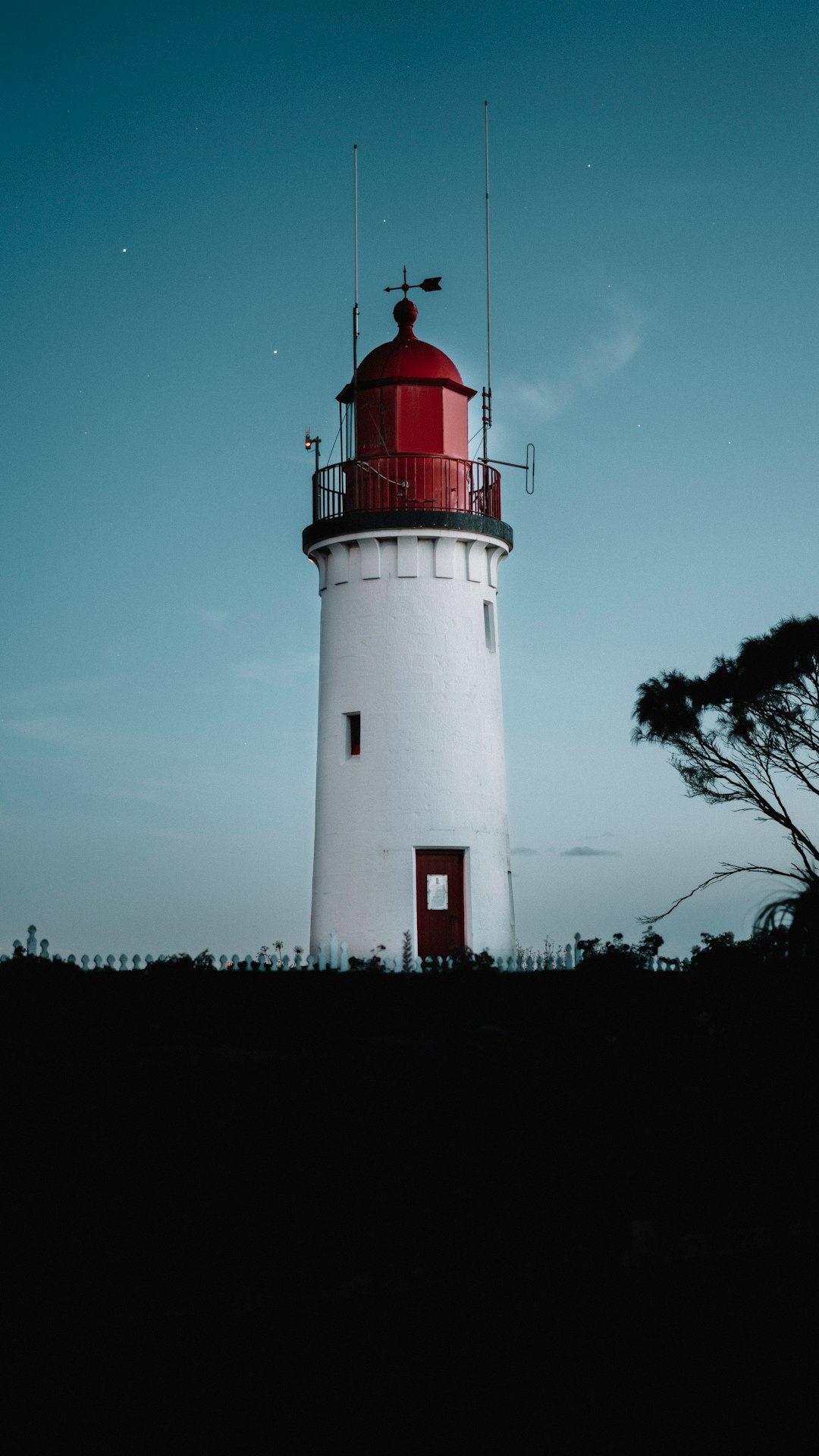 white and red light house under blue sky during daytime