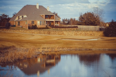 brown and white house near body of water during daytime