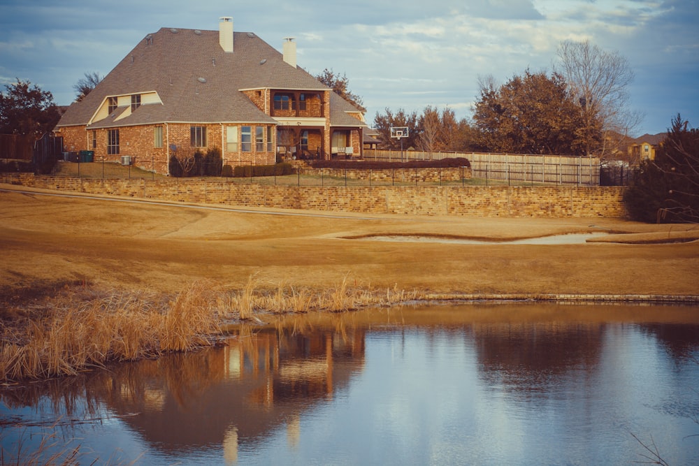 brown and white house near body of water during daytime