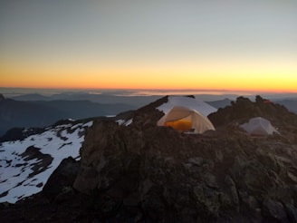 Sunset view of a small group camping at a mountain base camp.