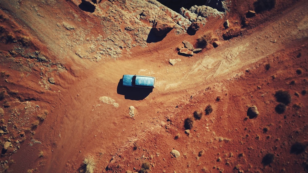 blue car on brown dirt