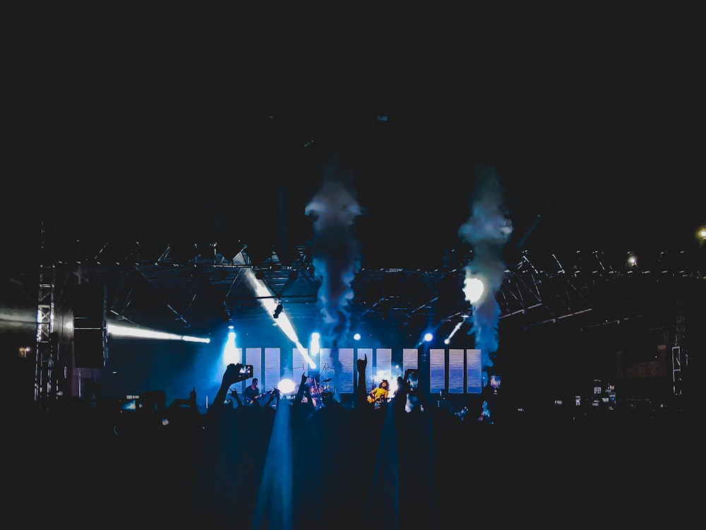 people standing on stage with blue lights