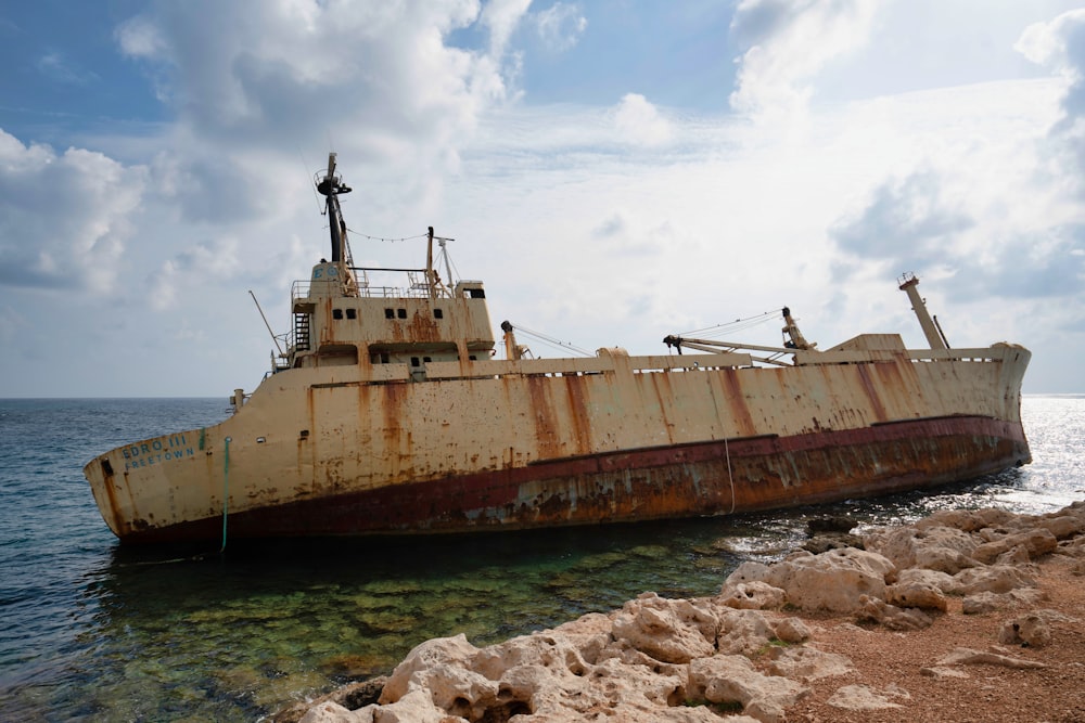 white and brown ship on sea under white clouds during daytime