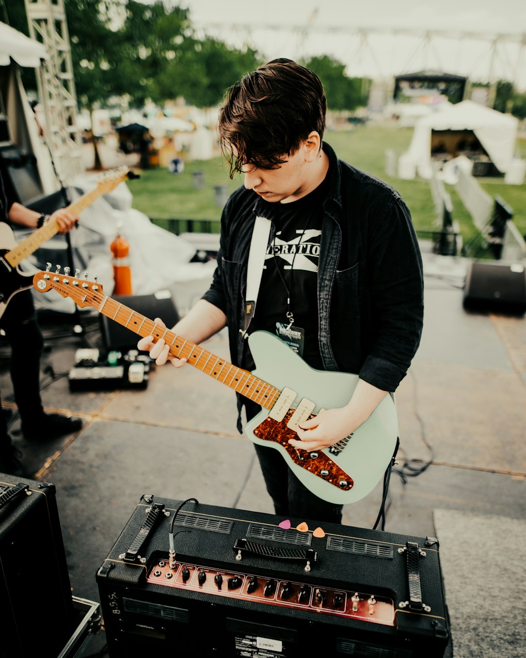 man in black long sleeve shirt playing electric guitar