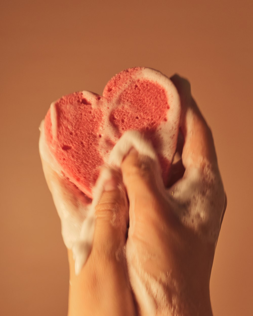 person holding pink and white heart shaped ornament