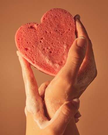 Hands holding a biodegradable sponge soaked with natural cleaning foam.