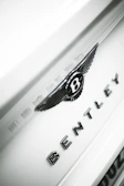 Luxury European car spare parts including Range Rover and Bentley badges on display.