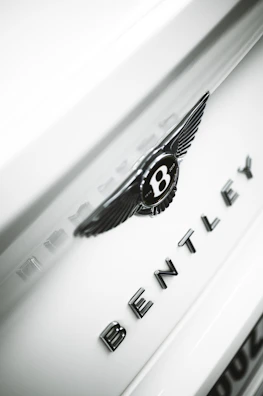 Luxury European car spare parts including Range Rover and Bentley badges on display.