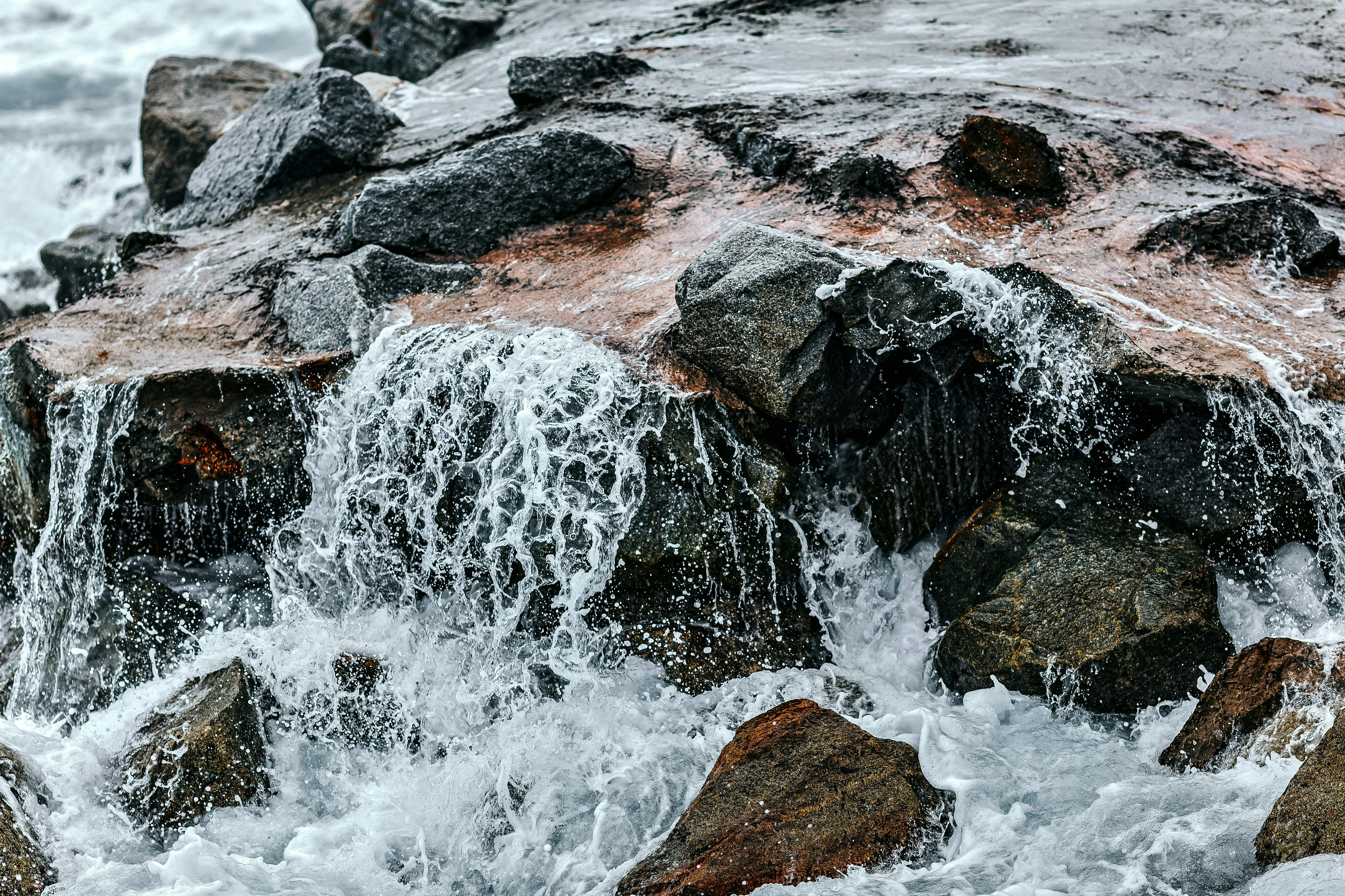 water waves hitting brown rock