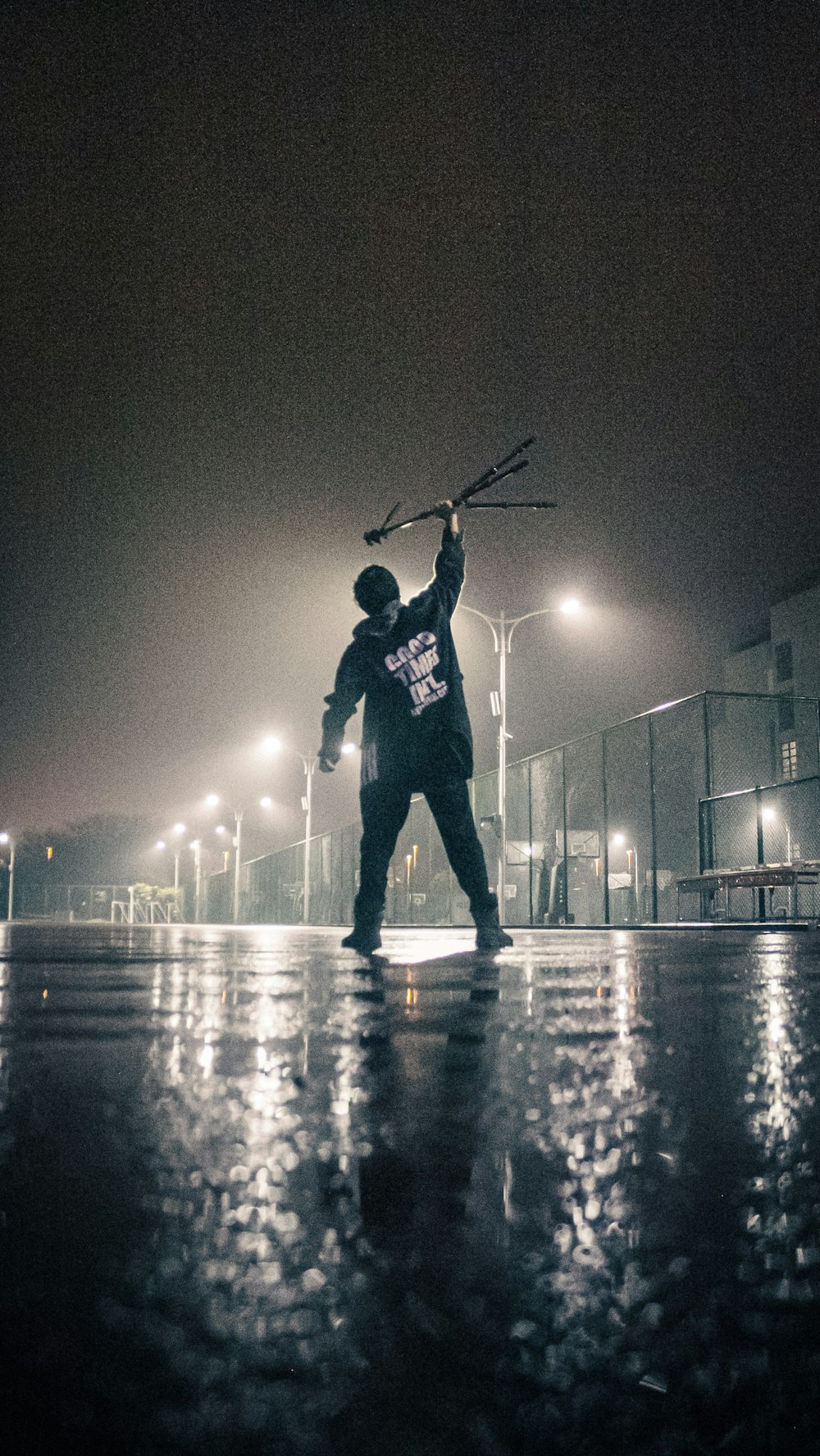 Hombre con chaqueta negra jugando al golf durante la noche