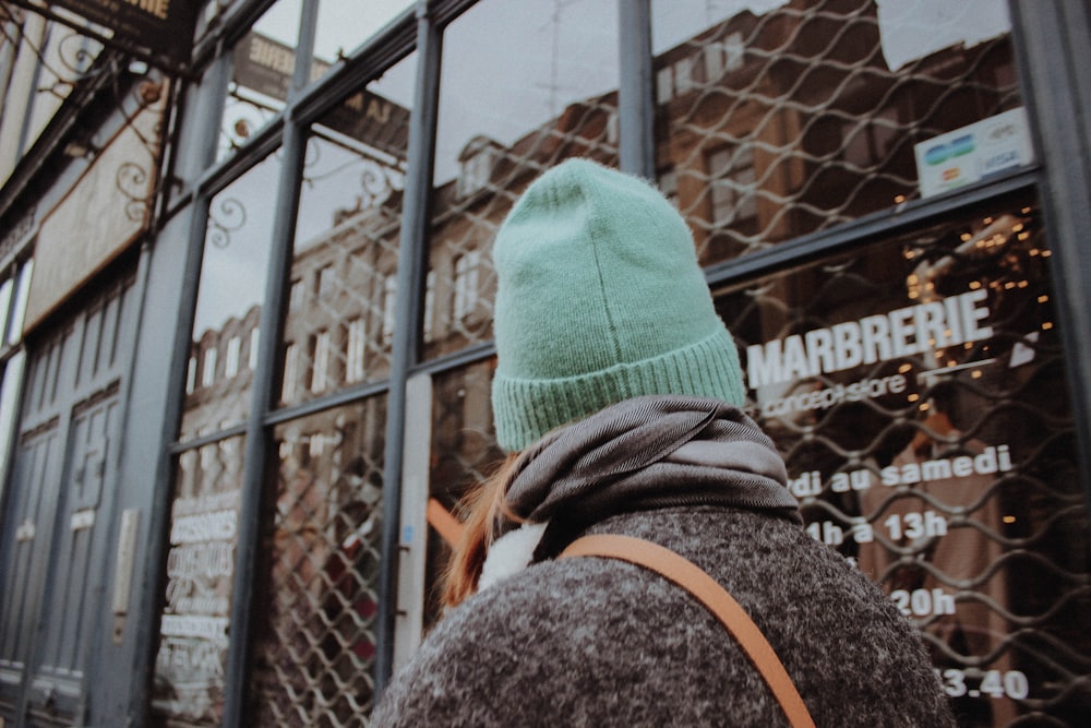 person in green knit cap and gray jacket