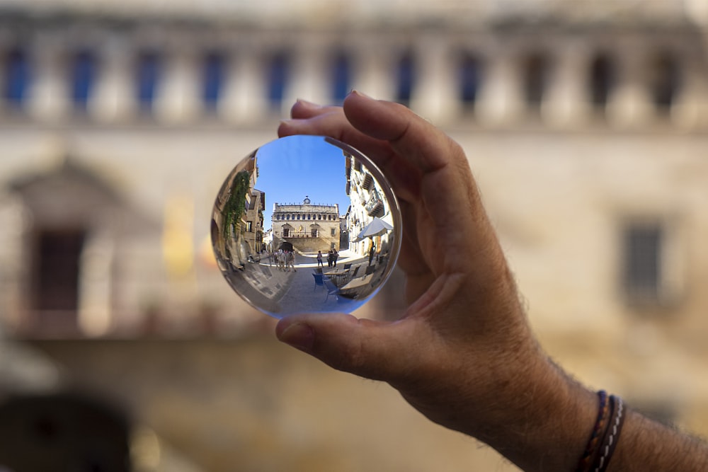 person holding clear glass ball