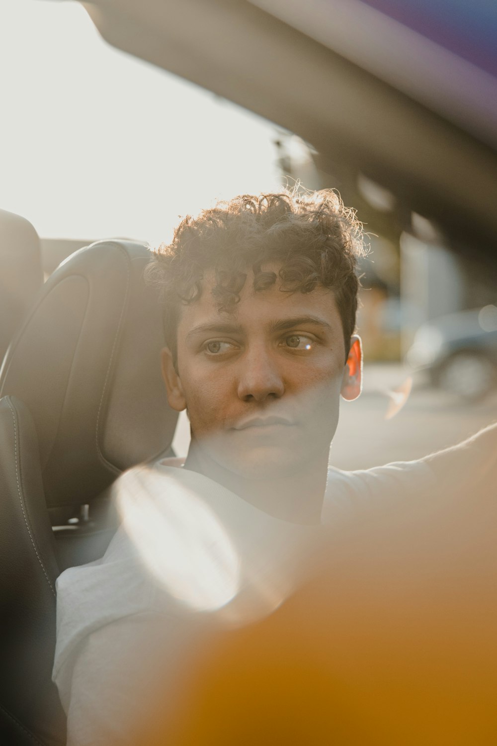 man in white dress shirt sitting on car seat