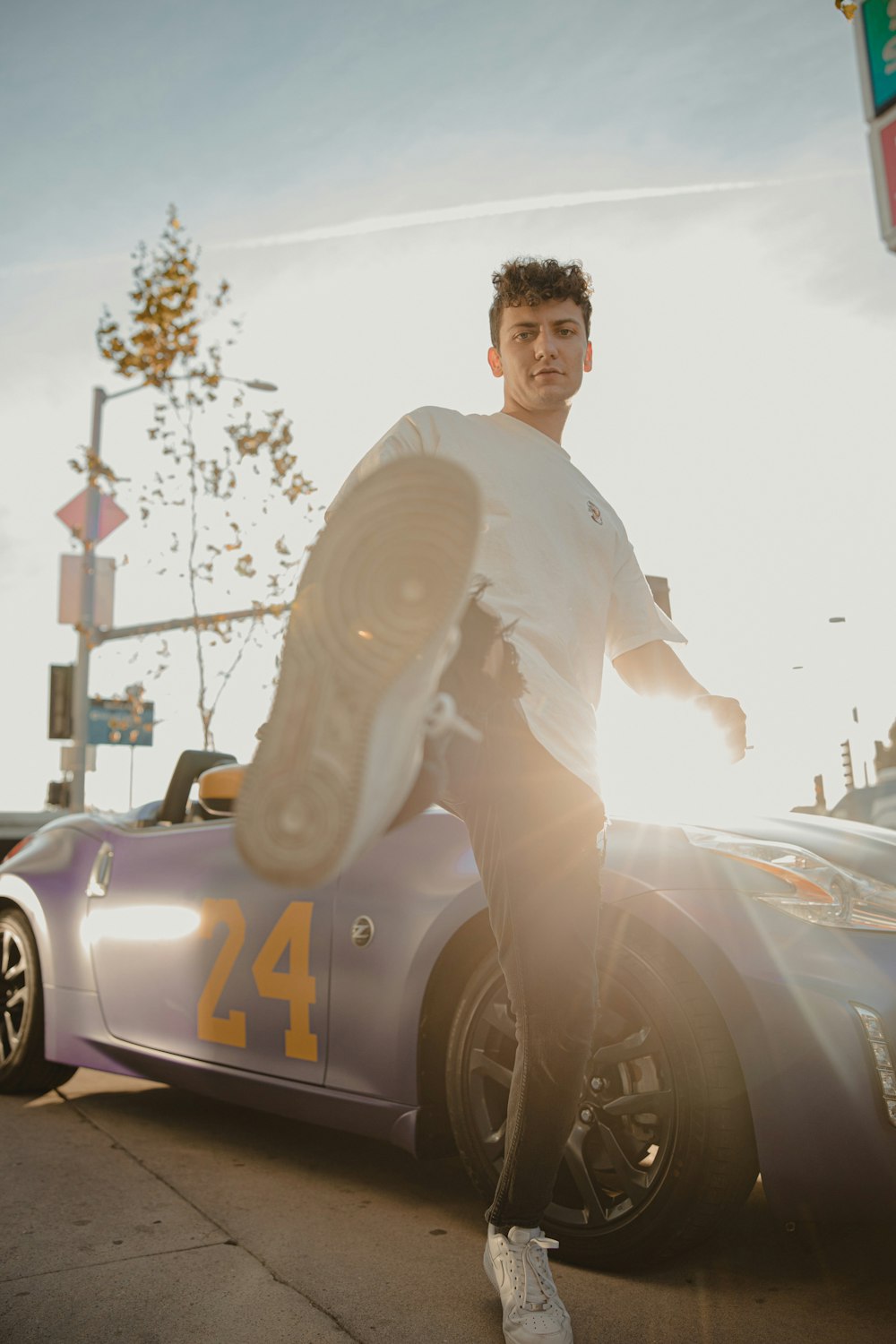 man in white dress shirt and brown pants sitting on yellow and black car