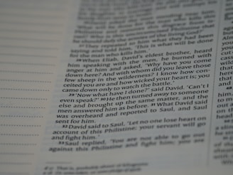 A close-up view of a page from a book, featuring text that includes dialogue and narrative. The text is written in a structured format with numbered paragraphs, suggesting it may be from a religious or historical text.