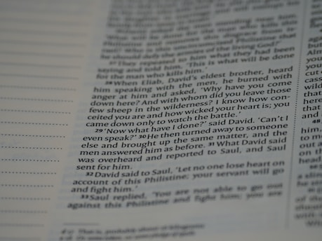 A close-up view of a page from a book, featuring text that includes dialogue and narrative. The text is written in a structured format with numbered paragraphs, suggesting it may be from a religious or historical text.