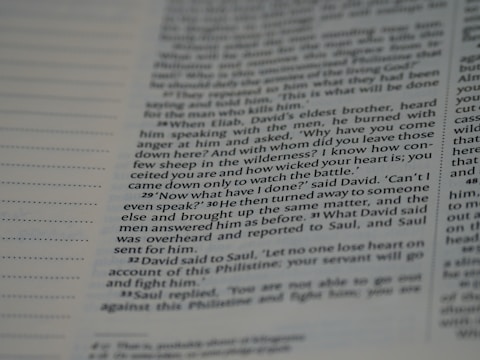 A close-up view of a page from a book, featuring text that includes dialogue and narrative. The text is written in a structured format with numbered paragraphs, suggesting it may be from a religious or historical text.