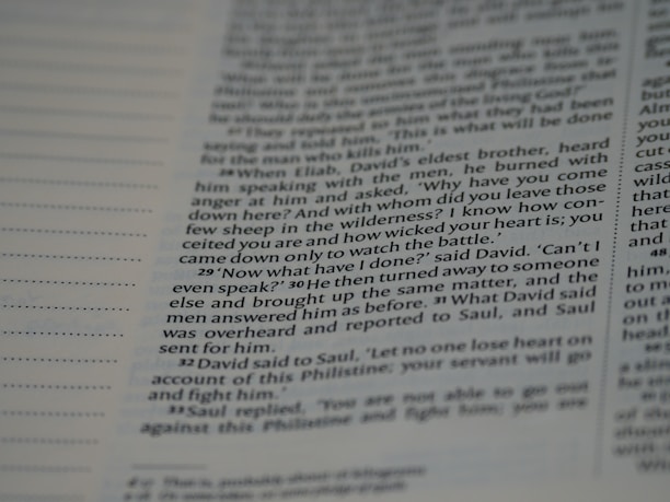 A close-up view of a page from a book, featuring text that includes dialogue and narrative. The text is written in a structured format with numbered paragraphs, suggesting it may be from a religious or historical text.