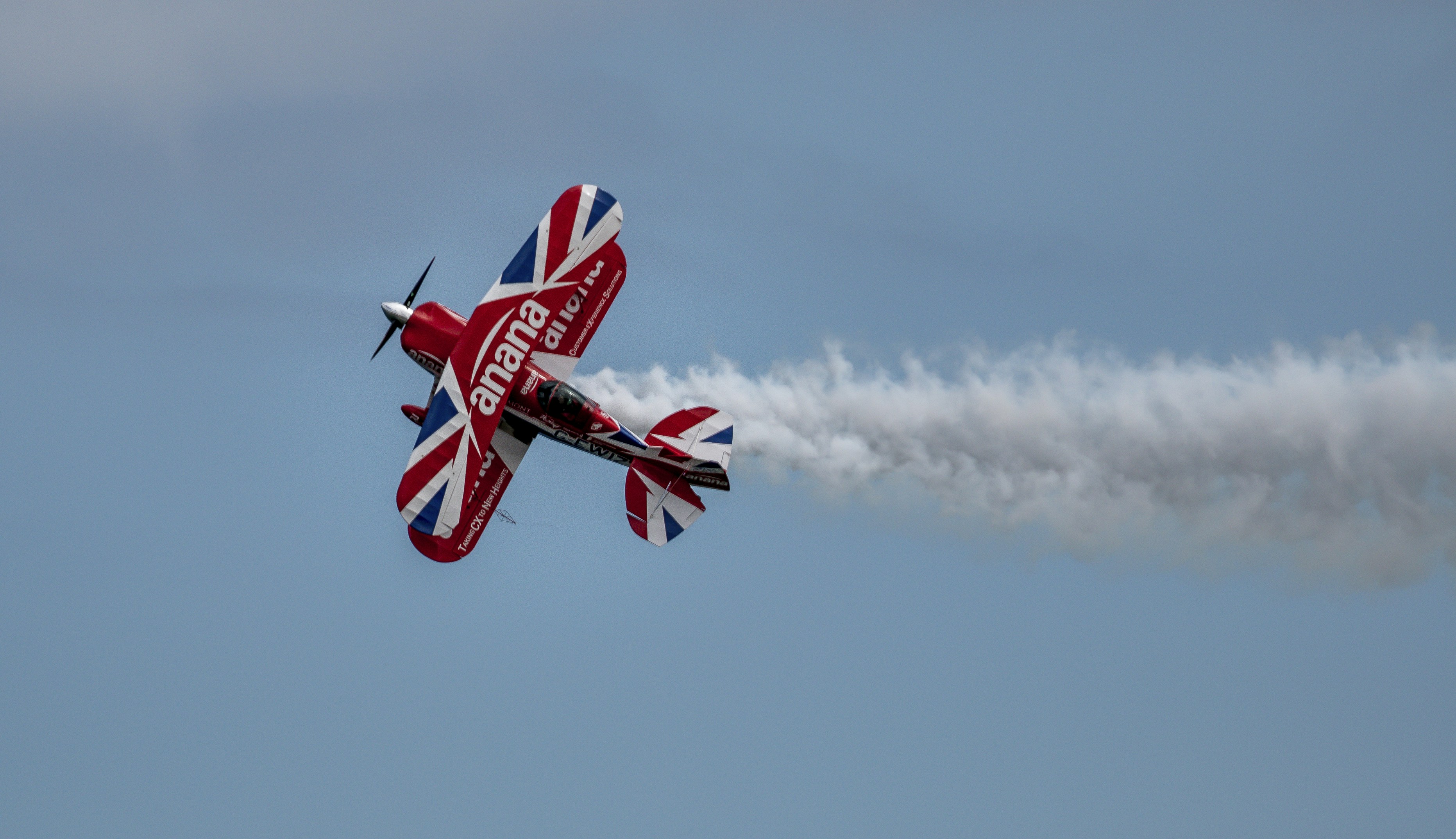 red and white plane flying in the sky