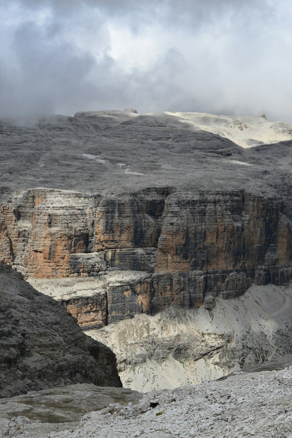 brown rocky mountain under white clouds during daytime