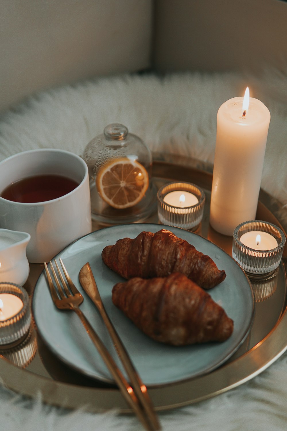 stainless steel fork beside white pillar candle