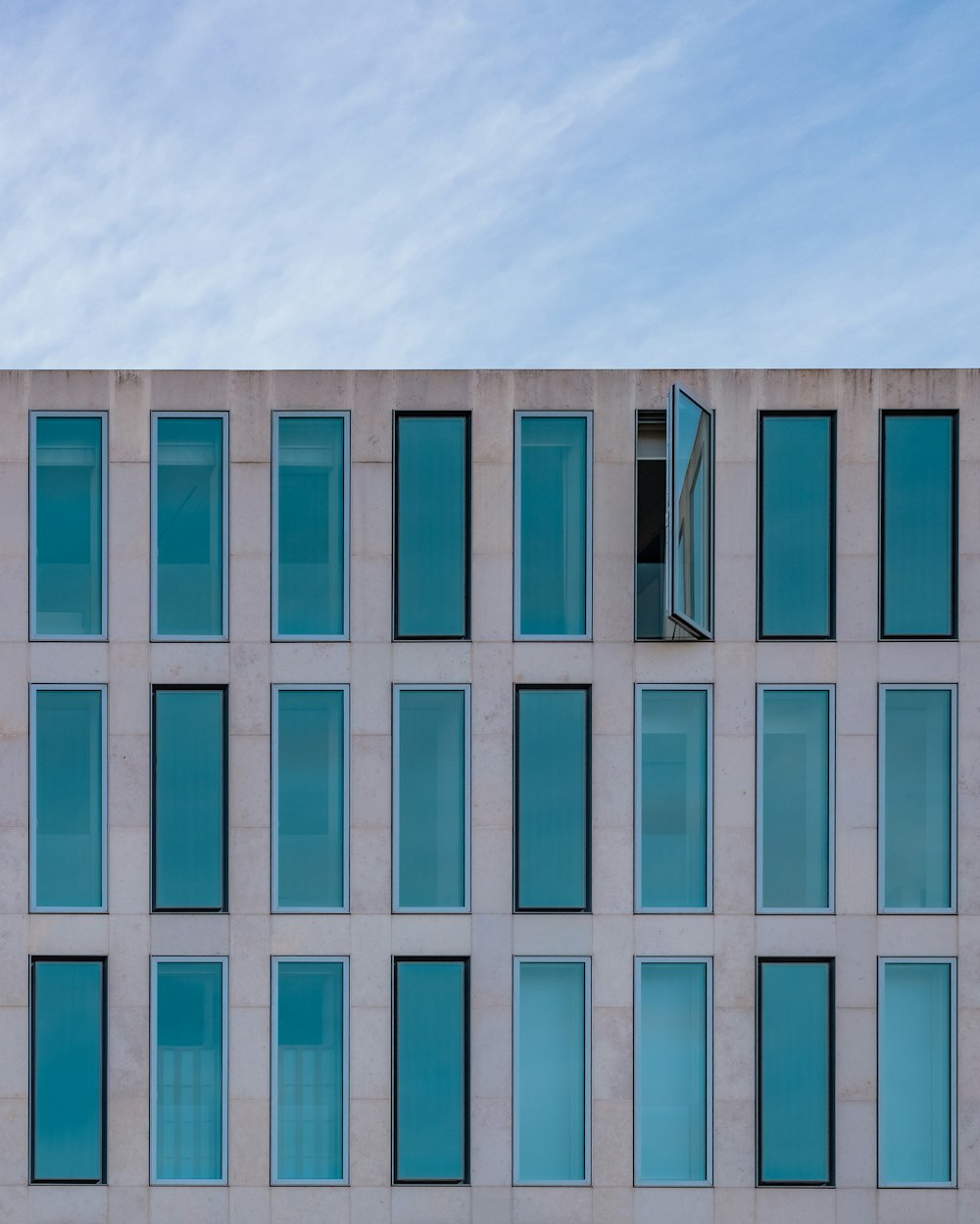 blue and white concrete building under white clouds during daytime