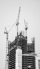 grayscale photo of crane near building