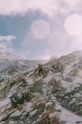 person in red jacket standing on snow covered mountain during daytime