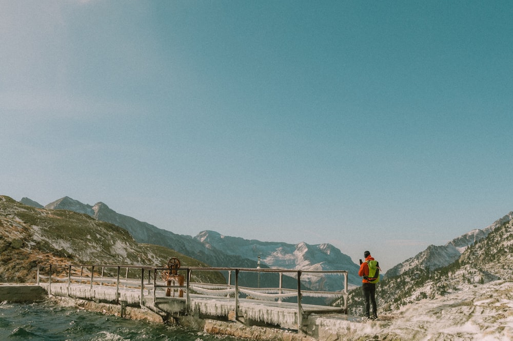 2 person walking on gray concrete bridge during daytime