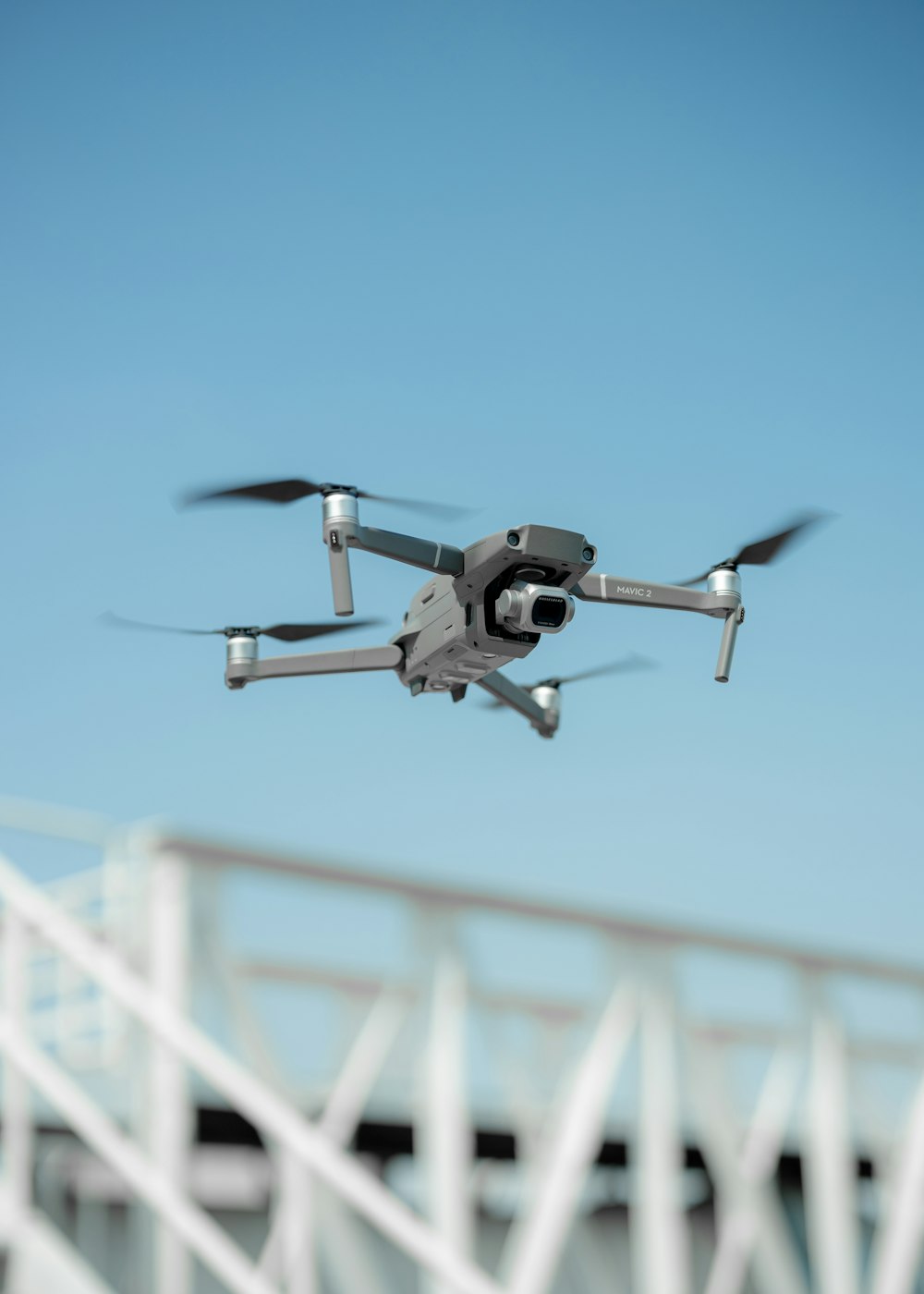 black and white drone flying in mid air during daytime