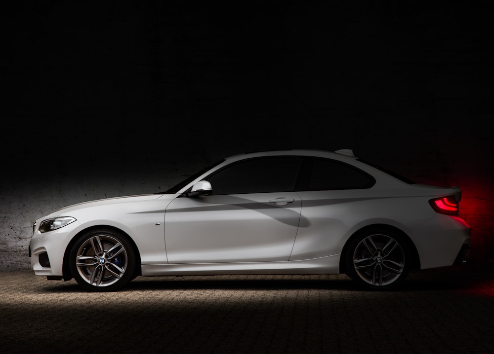 white coupe on black background