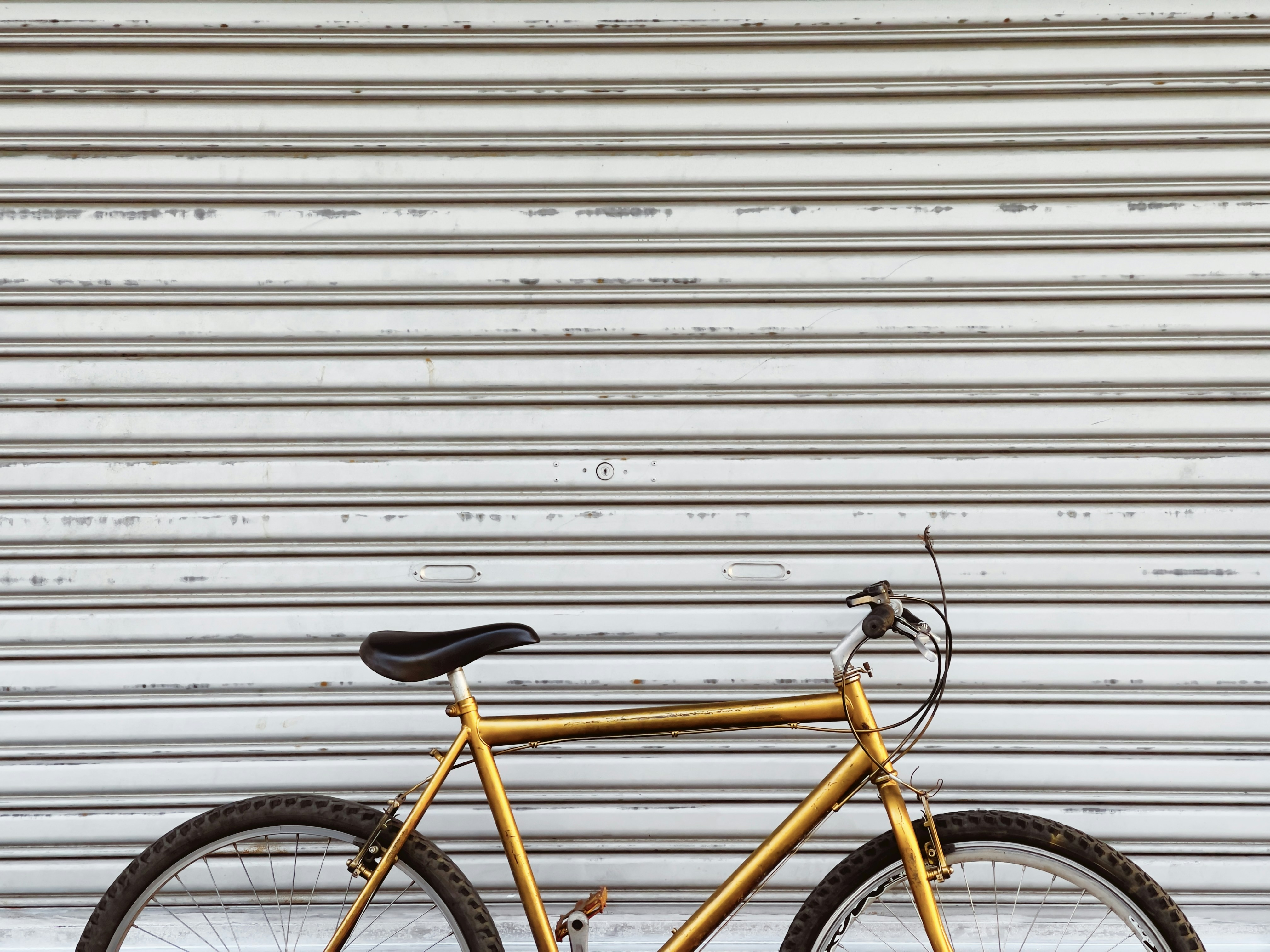 gelb-schwarzes Fahrrad an weiße Wand gelehnt