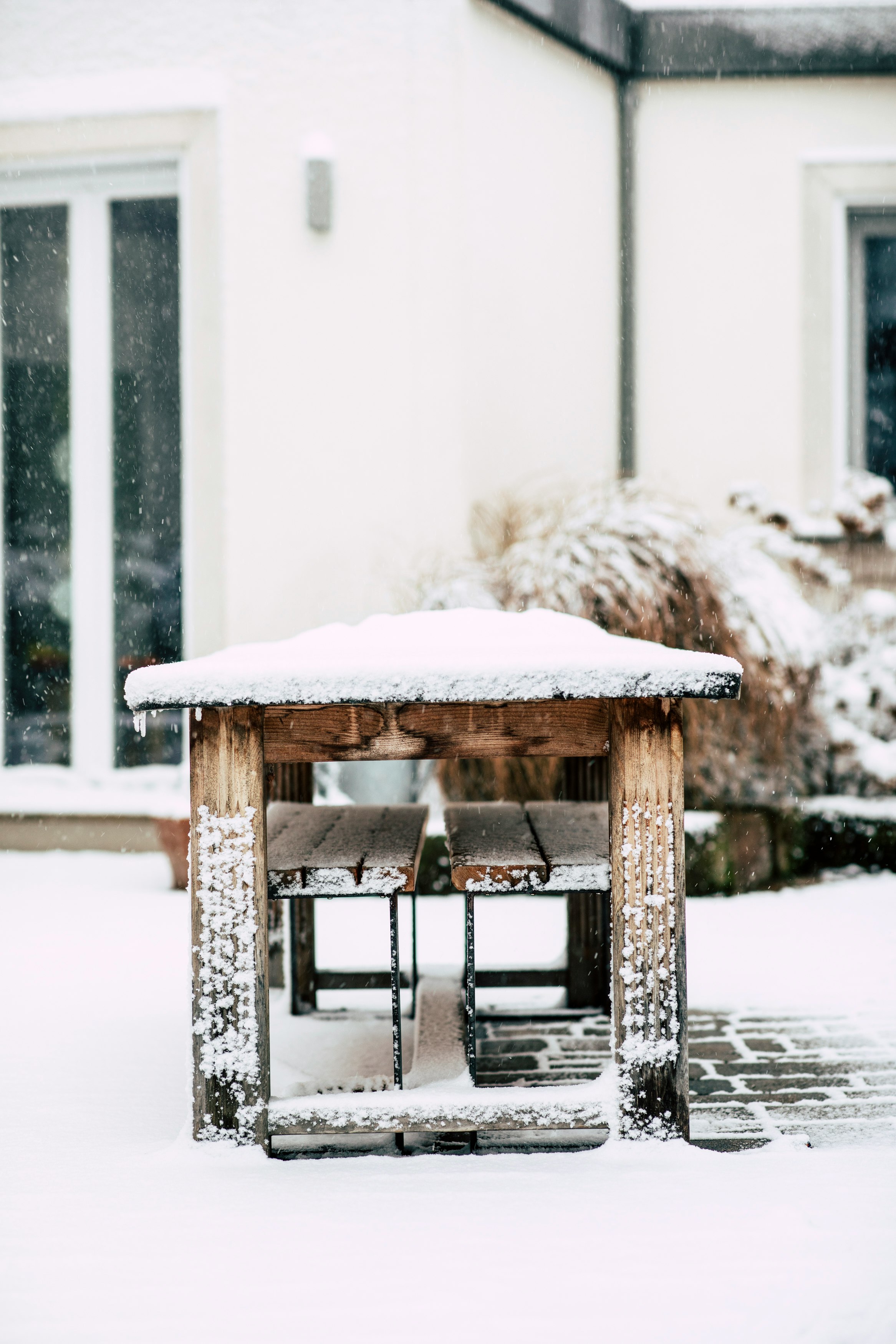 brown wooden table covered with snow