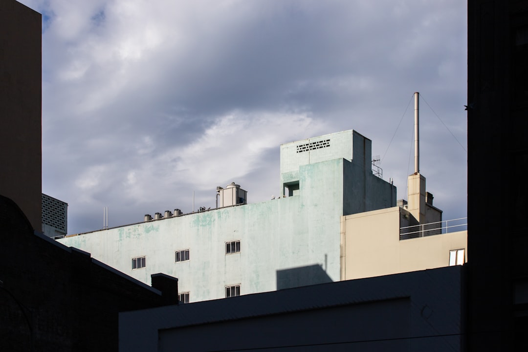 white concrete building under white clouds during daytime