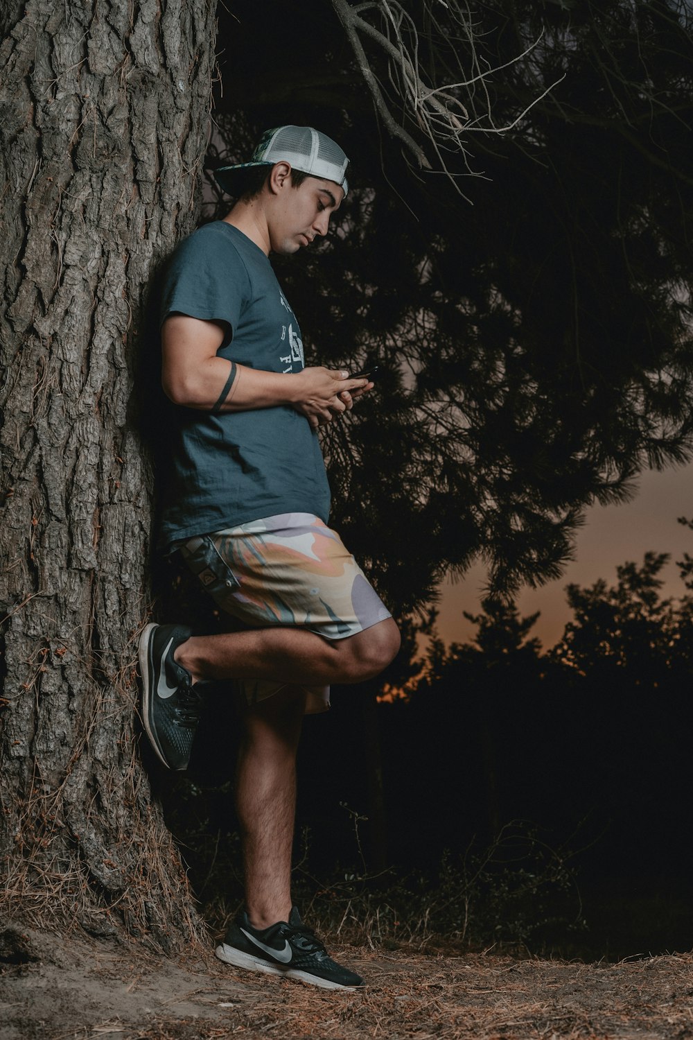 man in blue t-shirt sitting on tree trunk