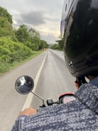 A woman riding a motorcycle on an open road.