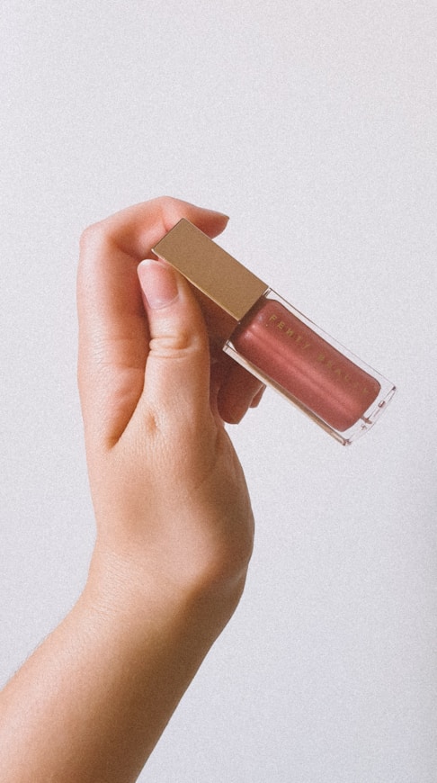 person holding pink nail polish