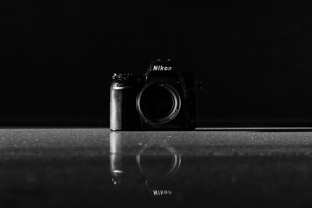 Cámara DSLR Nikon negra sobre superficie gris