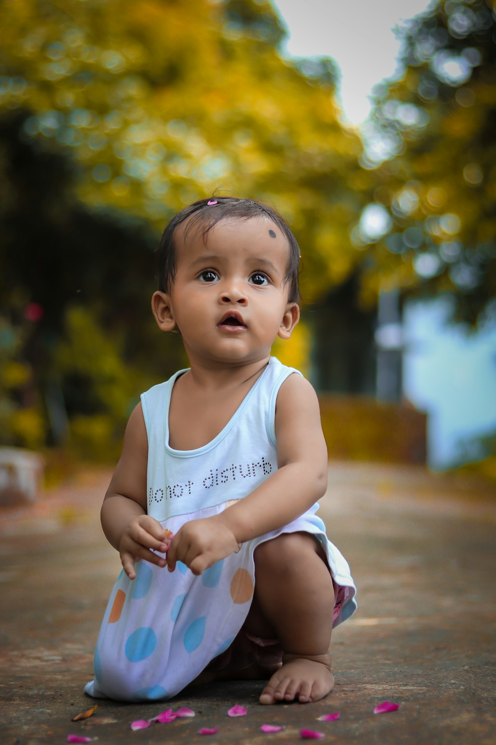 girl in white tank top standing on brown wooden floor during daytime