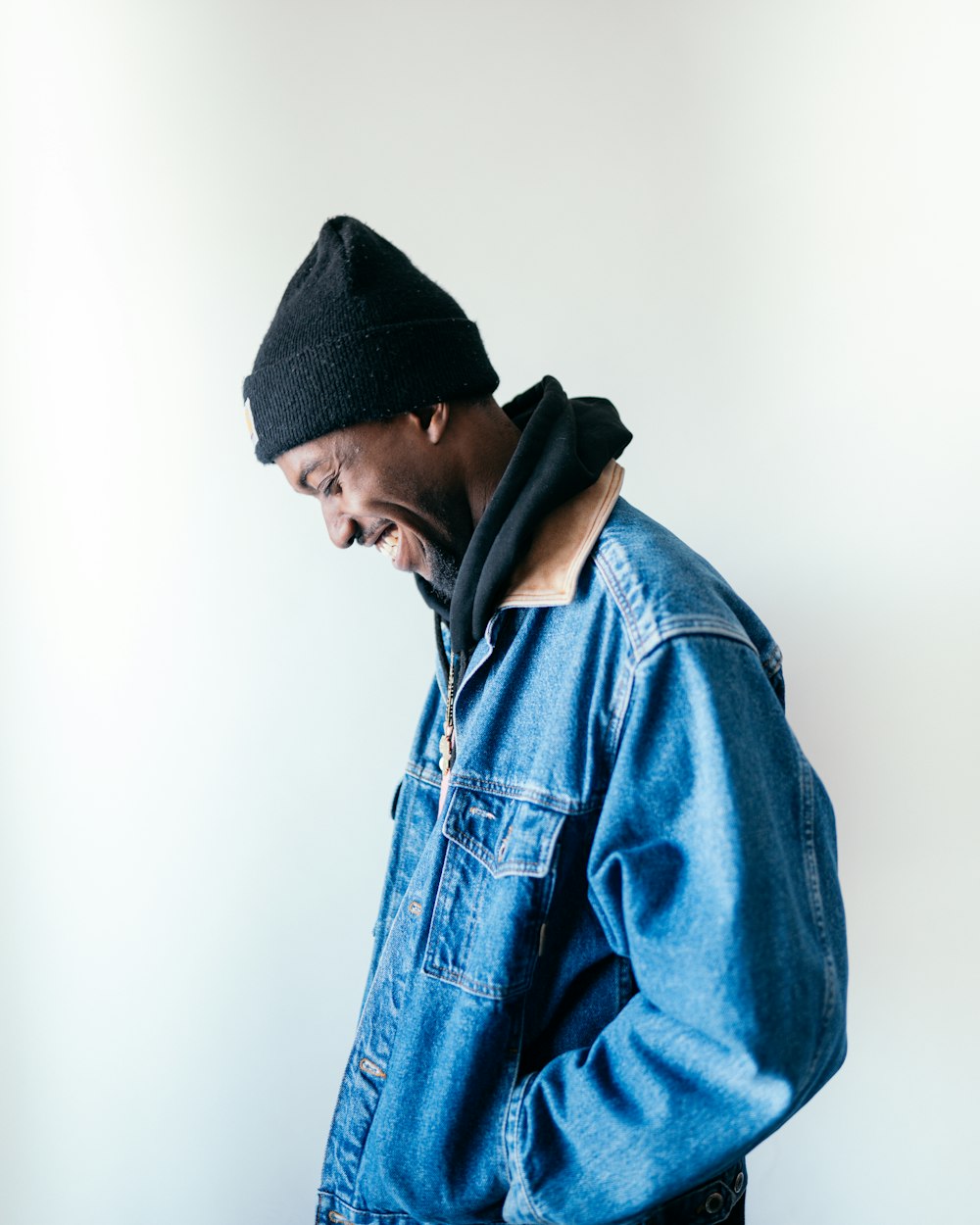 man in blue denim jacket wearing black knit cap