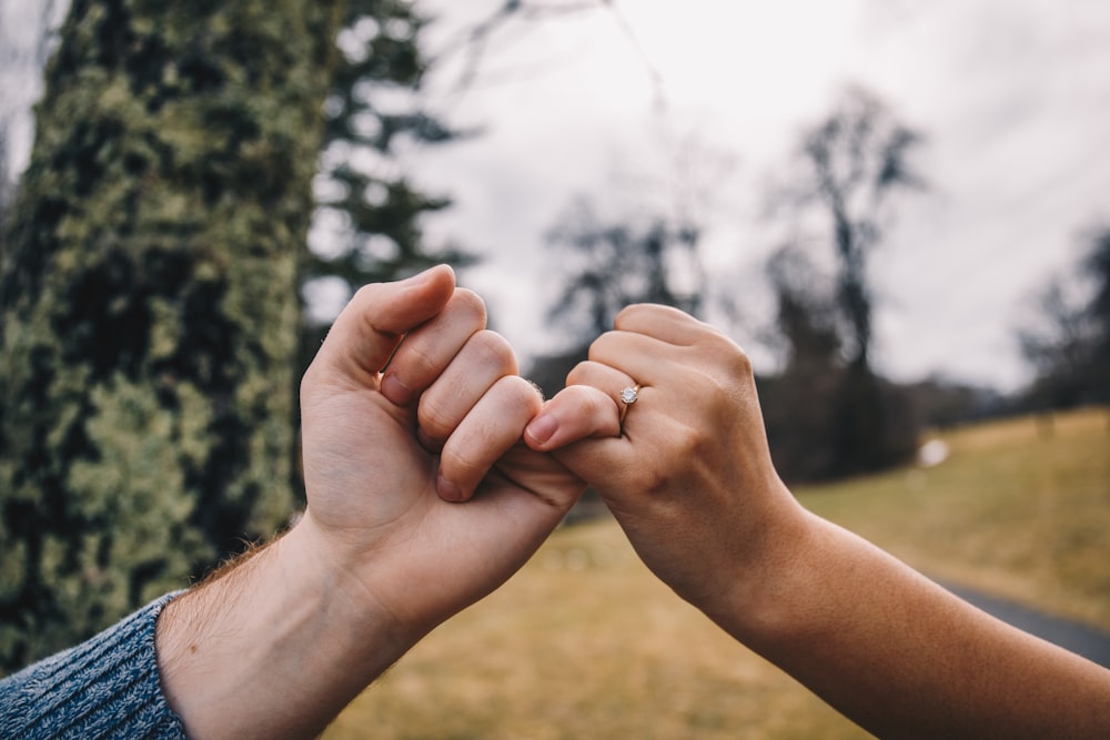 person holding hand of child during daytime