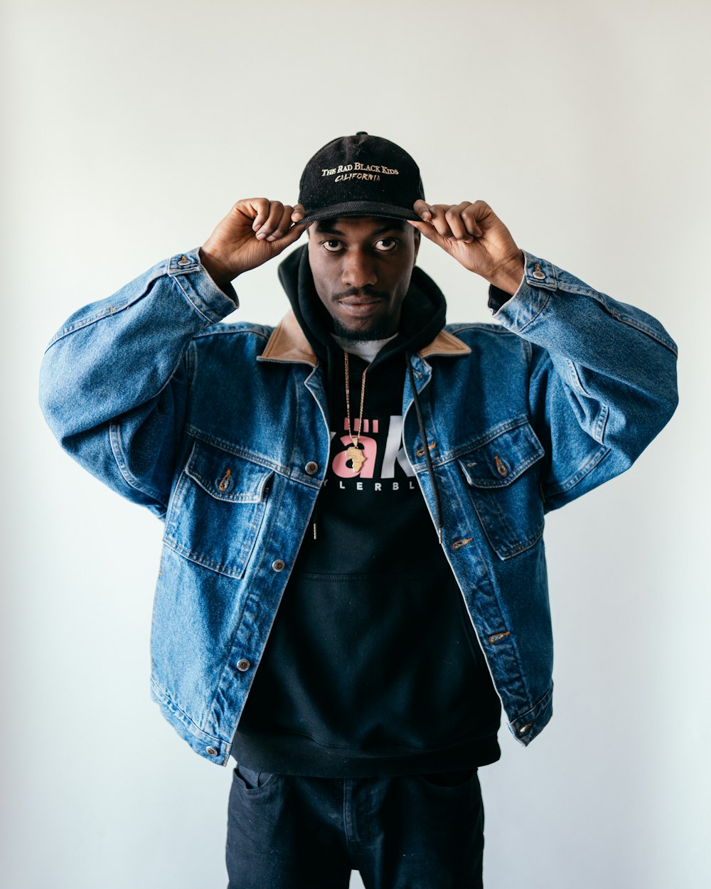 man in blue denim jacket and black fitted cap