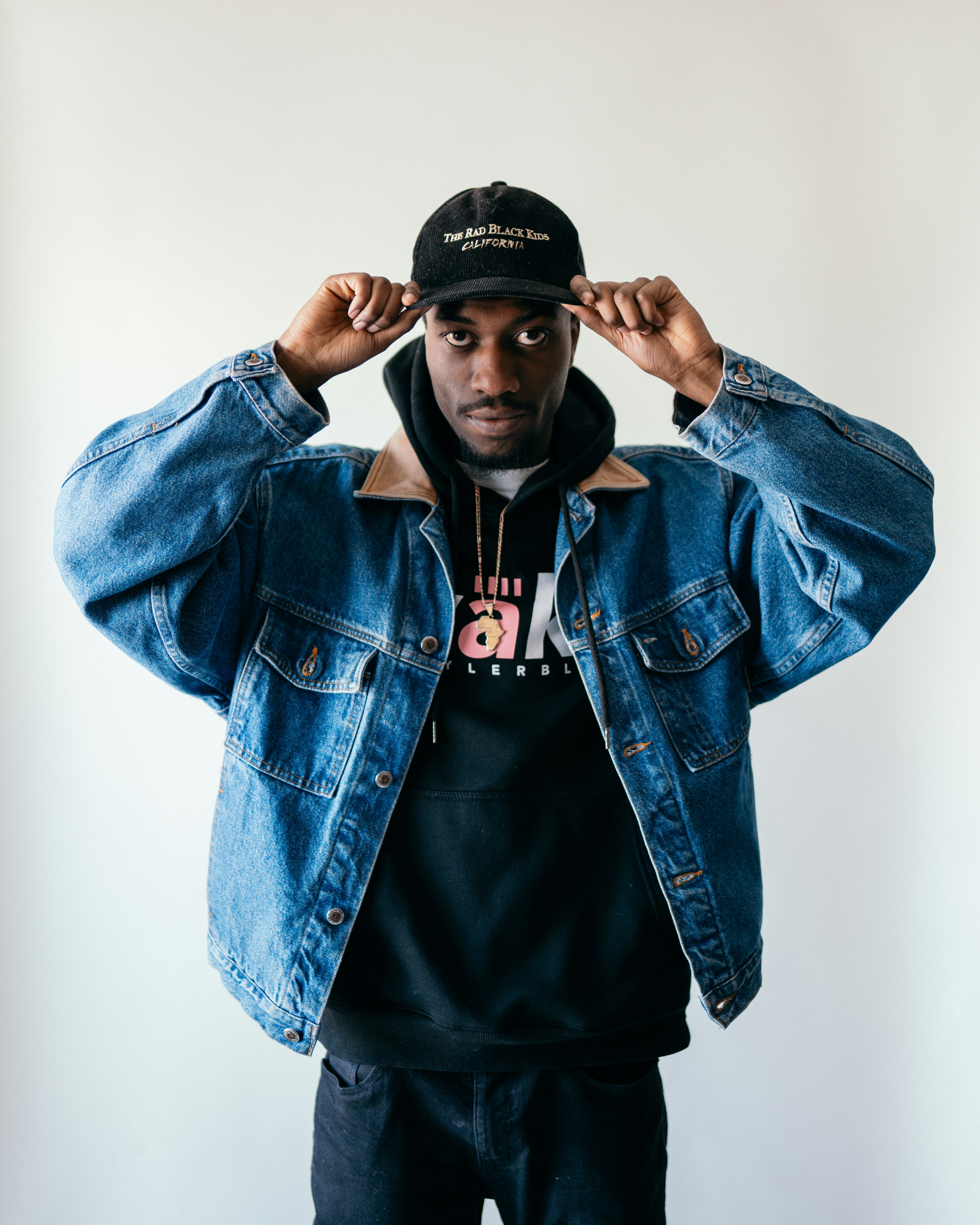 man in blue denim jacket and black fitted cap