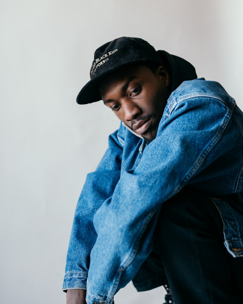 man in blue denim jacket and black hat