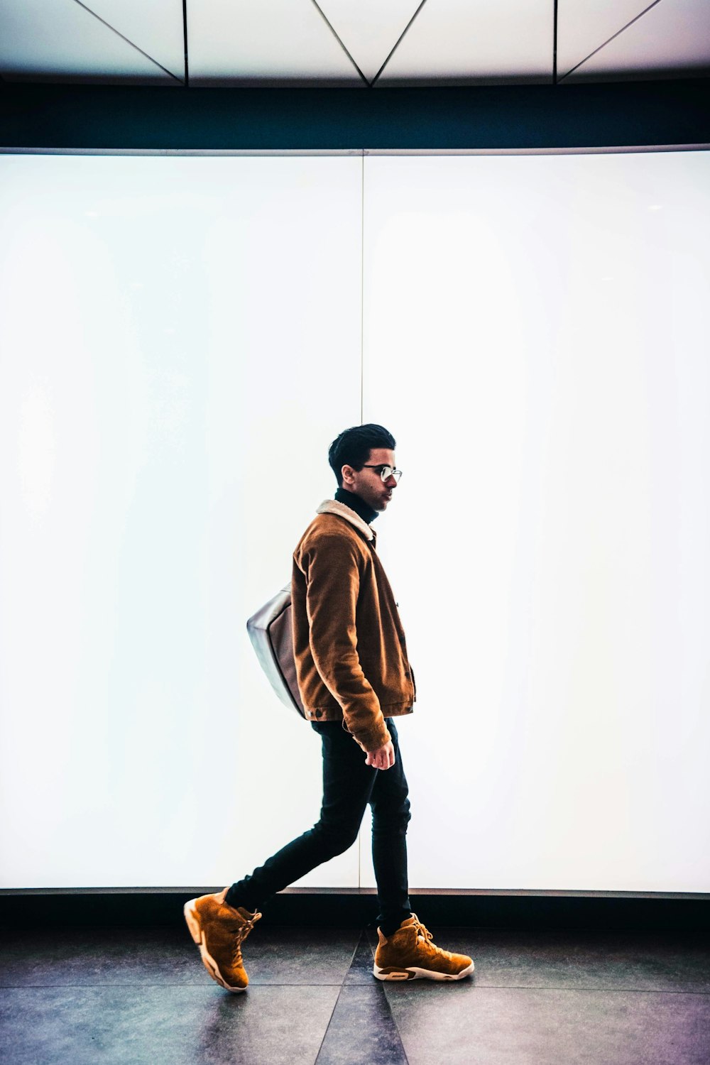 man in brown jacket and black pants standing