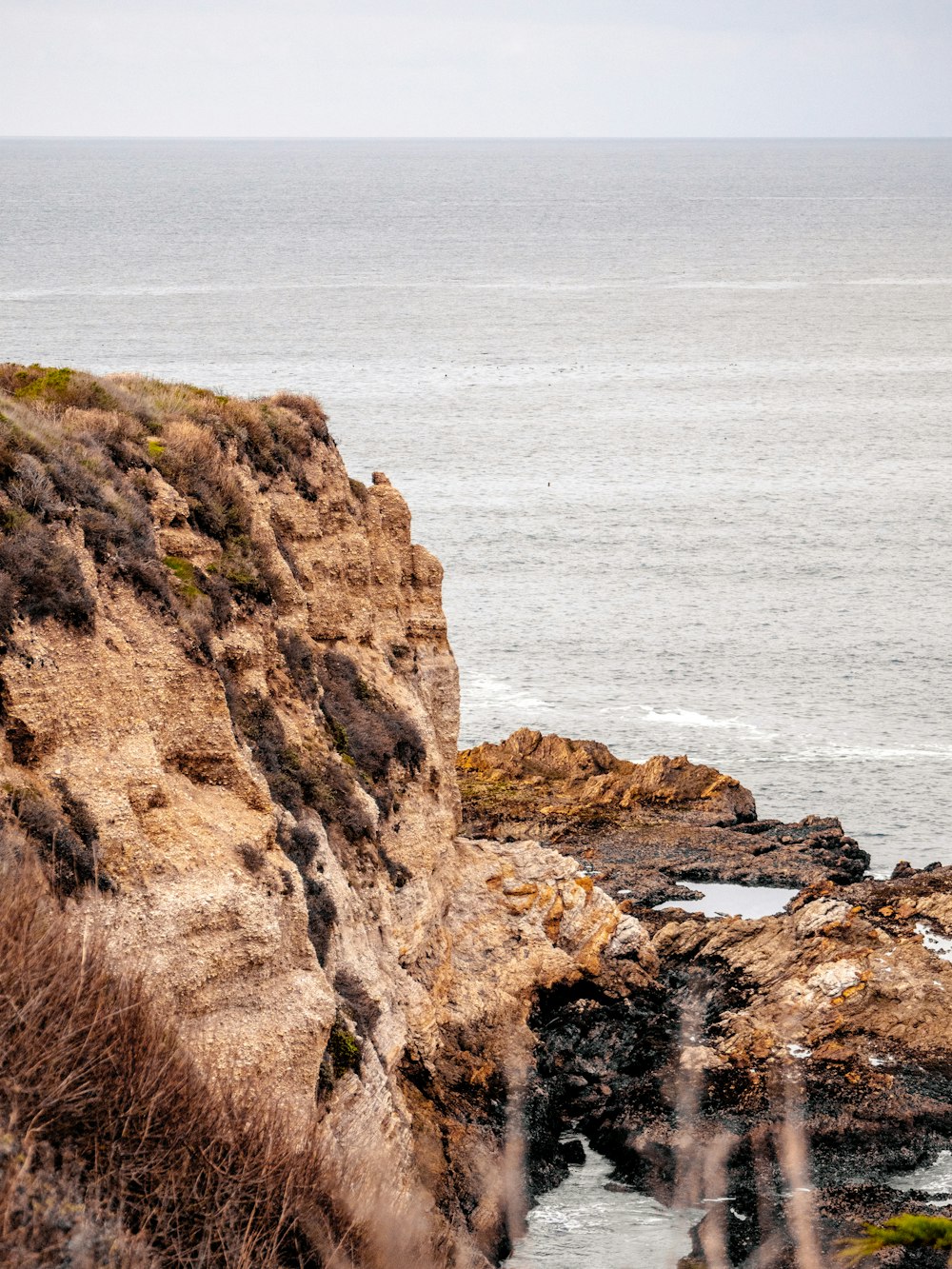 brown rock formation near body of water during daytime